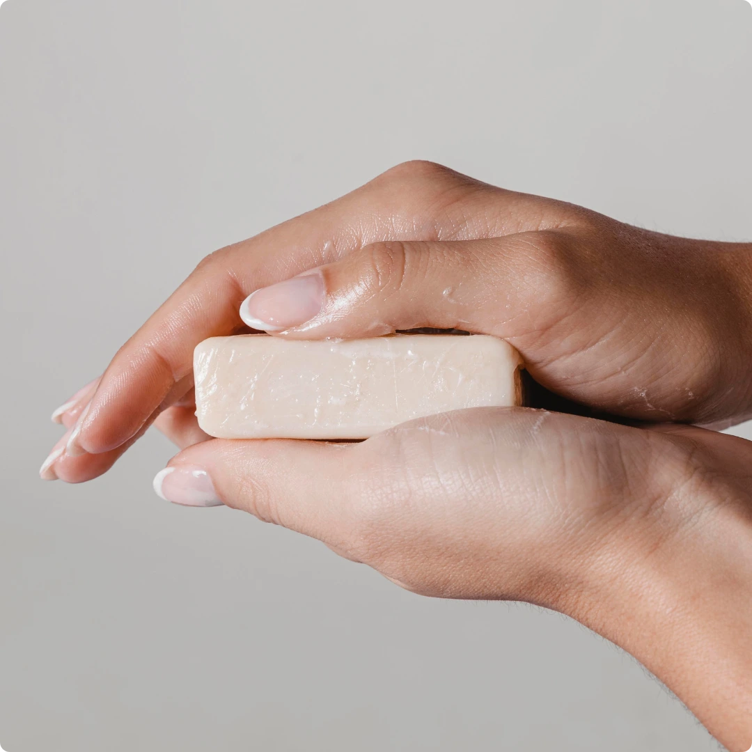 Hands holding a natural antibacterial soap — step one in how to cure body odor permanently