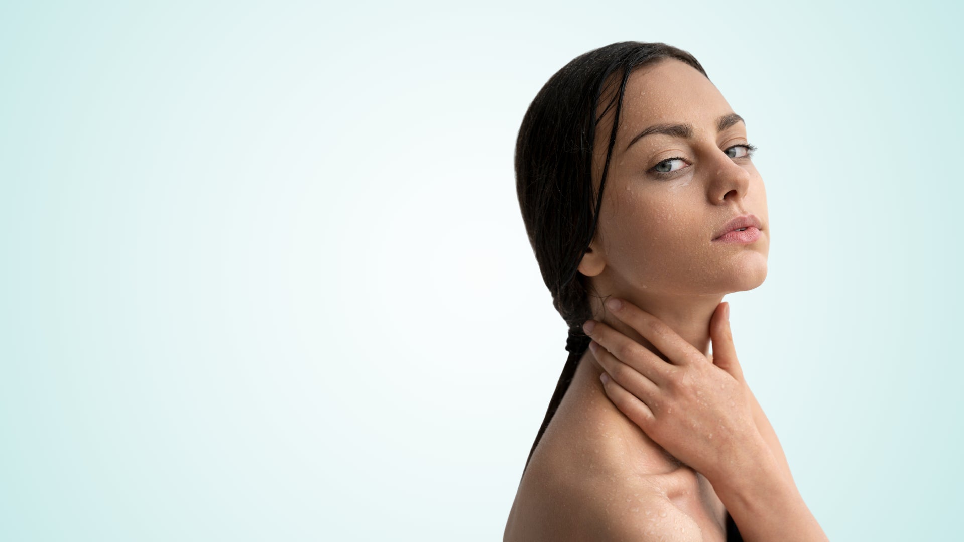 Woman with fresh, hydrated skin gently touching her neck after completing the Soaporize skincare ritual for odor-prone areas