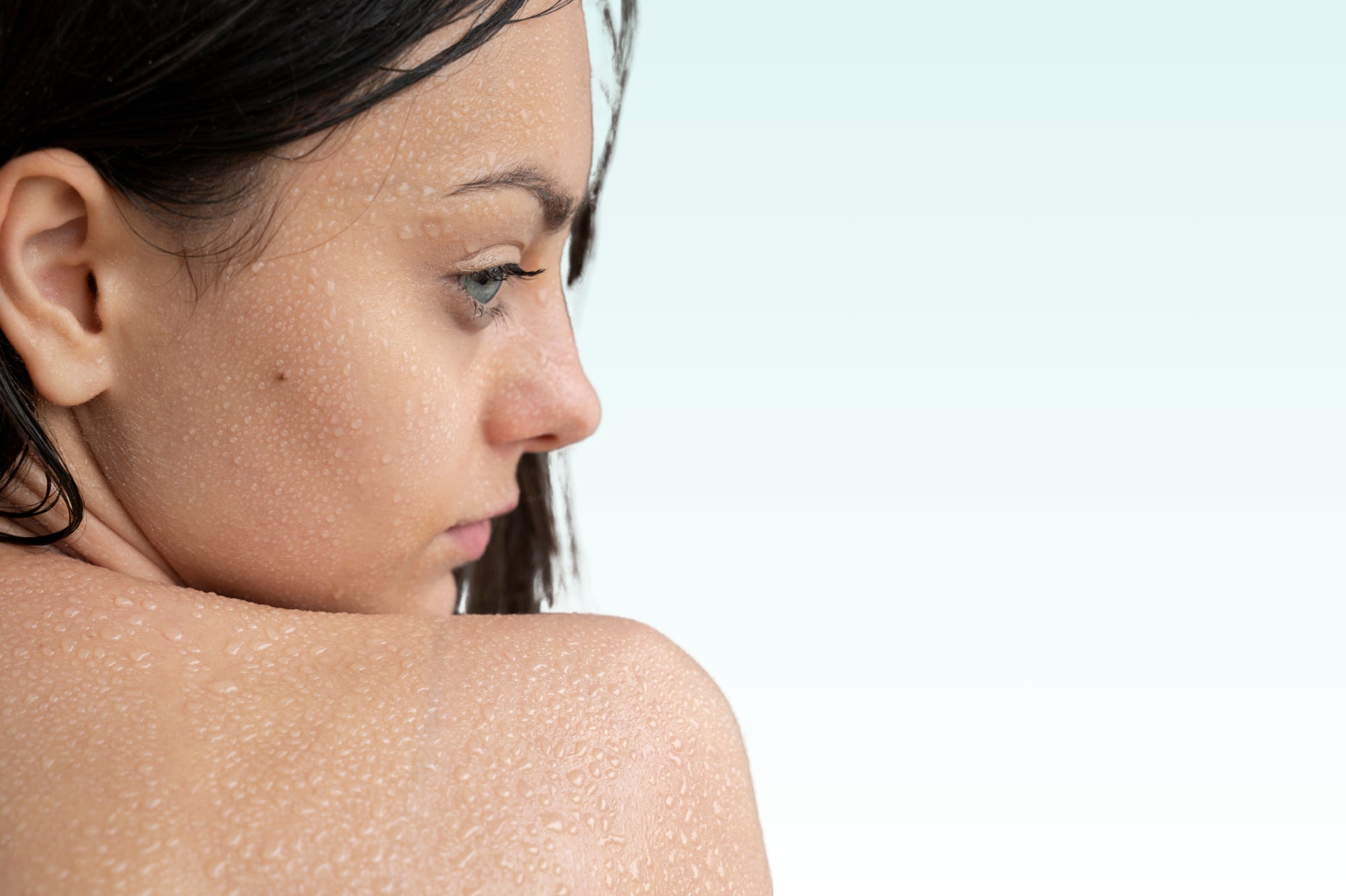 Post-shower skin close-up – soft light and water droplets